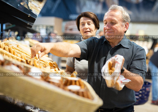 Couple chooses sweet puffs in bakery. Стоковое фото, фотограф Татьяна Яцевич / Фотобанк Лори