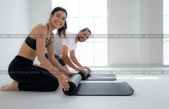 Couple doing yoga activities at home, Rolling up the yoga mat. Стоковое фото, агентство Ingram Publishing / Фотобанк Лори