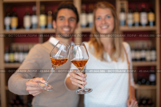 couple holding glasses tilted together in a toast. Стоковое фото, агентство Ingram Publishing / Фотобанк Лори