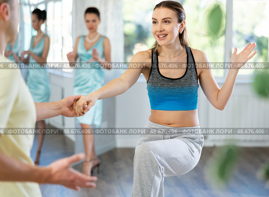 Couple in comfortable sports clothes learns boogie woogie dancing during individual lesson. Стоковое фото, фотограф Яков Филимонов / Фотобанк Лори