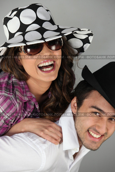 Couple messing around in hats. Стоковое фото, агентство Ingram Publishing / Фотобанк Лори