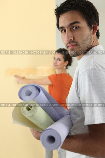 Couple ready to wallpaper wall. Стоковое фото, агентство Ingram Publishing / Фотобанк Лори