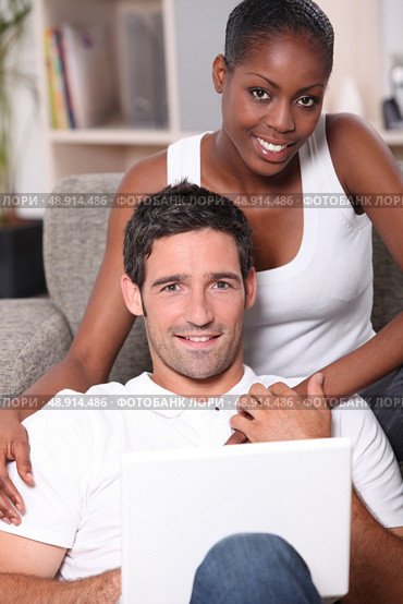 Couple sitting on sofa gray. Стоковое фото, агентство Ingram Publishing / Фотобанк Лори