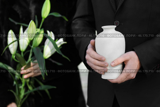 Couple with mortuary urn and flowers at funeral. Стоковое фото, фотограф Pixel_shot / Фотобанк Лори