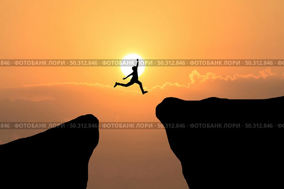 Courage man jump through the gap between hill ,Business concept idea. Стоковое фото, агентство Ingram Publishing / Фотобанк Лори