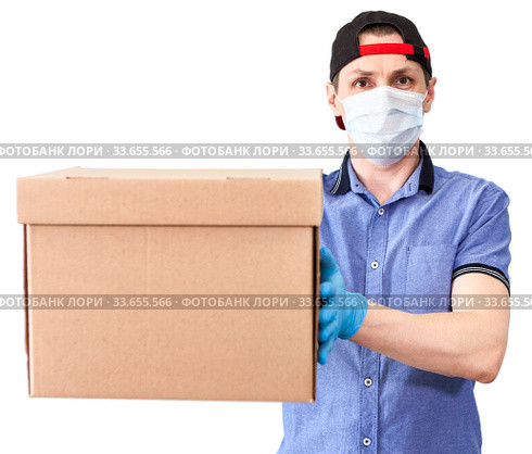 Courier stretching out cardboard box, delivery service, man with surgical mask and blue neoprene gloves, isolated on white background. Стоковое фото, фотограф Кекяляйнен Андрей / Фотобанк Лори