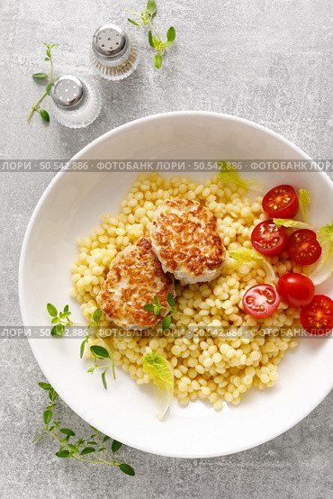 Couscous with chicken patties, cutlets and tomatoes, top down view. Стоковое фото, агентство Ingram Publishing / Фотобанк Лори