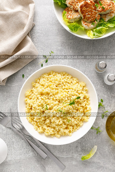 Couscous with chicken patties, cutlets with fresh romaine lettuce salad, top down view. Стоковое фото, агентство Ingram Publishing / Фотобанк Лори