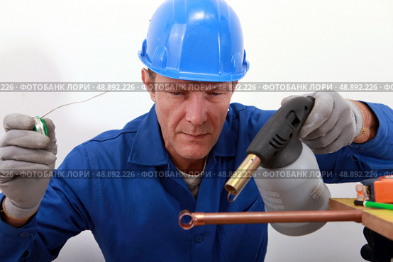 craftsman soldering a copper pipe. Стоковое фото, агентство Ingram Publishing / Фотобанк Лори