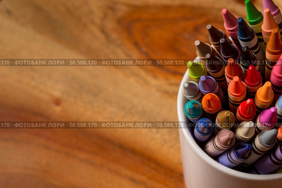 Crayons in a white mug sitting on a wooden desk. Стоковое фото, агентство Ingram Publishing / Фотобанк Лори