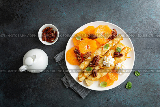 Crepes, thin pancakes with fresh tangerine slices, pecan nuts, syrup and whipped cream. Стоковое фото, агентство Ingram Publishing / Фотобанк Лори