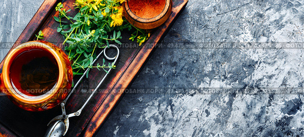 Cup with medicinal tea from Hypericum.Herbal medicine.Copy space. Tea with Hypericum flowers. Стоковое фото, агентство Ingram Publishing / Фотобанк Лори