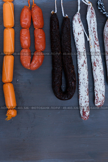 Cured meat and sausages hanging a rack at market, vertical shot. Cured meat and sausages. Стоковое фото, агентство Ingram Publishing / Фотобанк Лори