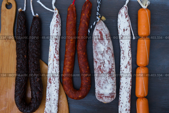 Cured meat and sausages hanging a rack. Cured meat and sausages. Стоковое фото, агентство Ingram Publishing / Фотобанк Лори
