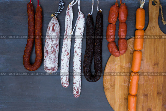 Cured meat and sausages hanging at market. Cured meat and sausages. Стоковое фото, агентство Ingram Publishing / Фотобанк Лори