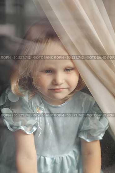 Curious Girl Gazing Through the Window, Embracing a World Full of Wonder and Imagination. Стоковое фото, фотограф Aleksandr Golubev / Фотобанк Лори