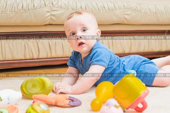 cute baby boy laying carpet with toys. Стоковое фото, агентство Ingram Publishing / Фотобанк Лори