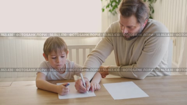 Dad teaches his son writing and counting. Kids primary education. Children learn, study in home school. Daddy male helping teaching little child boy support studying, learning homework. Knowledge day. Стоковое видео, видеограф Марина Демидюк / Фотобанк Лори