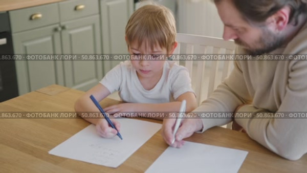 Dad teaches his son writing and counting. Kids primary education. Children learn, study in home school. Daddy male helping teaching little child boy support studying, learning homework. Knowledge day. Стоковое видео, видеограф Марина Демидюк / Фотобанк Лори