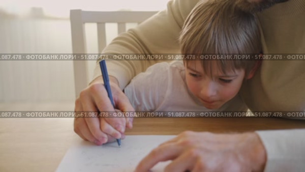 Dad teaches his son writing and counting. Kids primary education. Children learn, study in home school. Daddy male helping teaching little child boy support studying, learning homework. Knowledge day. Стоковое видео, видеограф Марина Демидюк / Фотобанк Лори