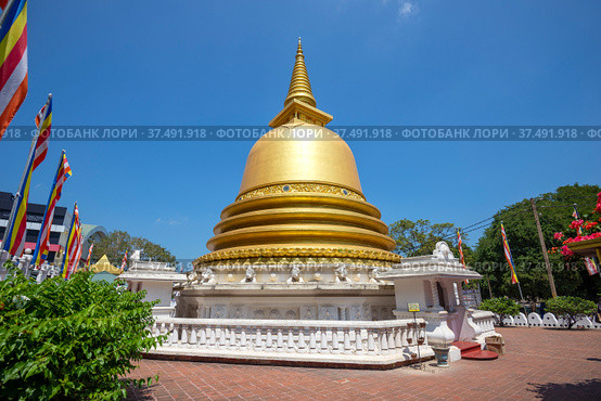 DAMBULLA, SRI LANKA - FEBRUARY 08, 2020: Golden Buddhist stupa close-up on a sunny day. Golden temple in Dambulla. Редакционное фото, фотограф Виктор Карасев / Фотобанк Лори