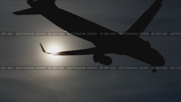 Dark airplane silhouettes descending against glowing sunset sky, highlighting striking contrast between aircraft outlines and warm golden illumination, capturing dramatic aviation moment. Стоковое видео, видеограф Данил Руденко / Фотобанк Лори
