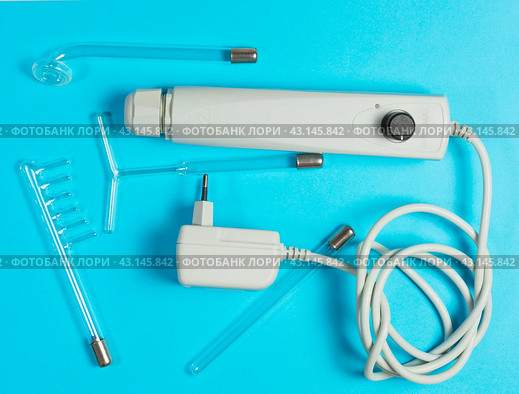 Darsonval on a blue background, taking care of yourself at home . medical device for the treatment of acne, cellulite, hair at home and in Spa centers. flat lay. Стоковое фото, фотограф Дмитрий Львович Алферов / Фотобанк Лори