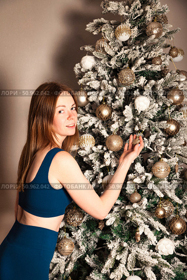 Decorating Christmas Tree Brings Joy to This Pretty Woman. Стоковое фото, фотограф Aleksandr Golubev / Фотобанк Лори