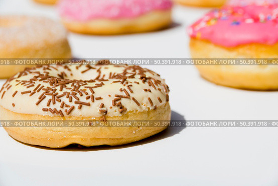 delicious donuts with sprinkles white backdrop. Стоковое фото, агентство Ingram Publishing / Фотобанк Лори