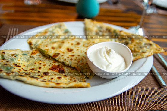 Delicious gourmet flat bread kutabs with herbs and cheese on a plate. Стоковое фото, фотограф Евгений Ткачёв / Фотобанк Лори