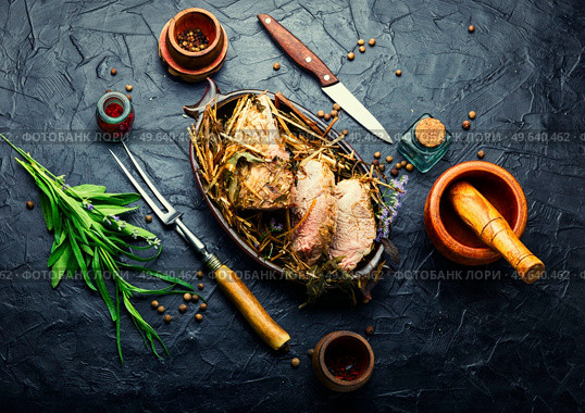 Delicious meat roasted in fresh hay. Baked pork meat in spicy herbs.Autumn food. Roast pork in hay with herbs. Стоковое фото, агентство Ingram Publishing / Фотобанк Лори