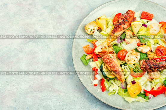 Delicious salad of fresh vegetables, herbs and fried octopus tentacles. Appetizing seafood salad. Стоковое фото, агентство Ingram Publishing / Фотобанк Лори