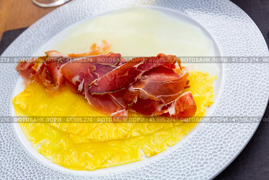 Delicious serving of pineapple and melon carpaccio with thinly sliced prosciutto. Стоковое фото, фотограф Яков Филимонов / Фотобанк Лори