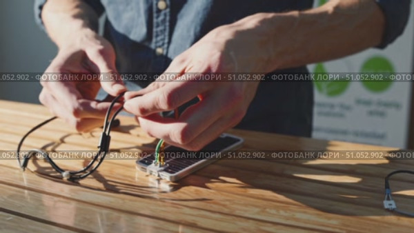 Demonstrating Cable Connections for a Solar Charger Device: Exploring the Assembly Process of Power Sources Utilizing Solar Energy Technologies. Стоковое AI-видео, аниматор Владимир Федоров / Фотобанк Лори