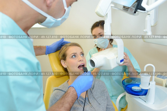 dentist curing a woman patient in the dental office. Стоковое фото, агентство Ingram Publishing / Фотобанк Лори