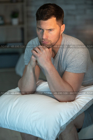 depressed man sitting on his bed and feeling bad. Стоковое фото, агентство Ingram Publishing / Фотобанк Лори
