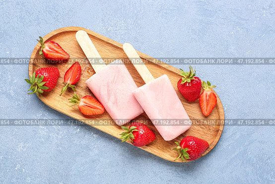 Деревянная доска с вкусными клубничными морожеными на голубом фоне. Стоковое фото, фотограф Pixel_shot / Фотобанк Лори