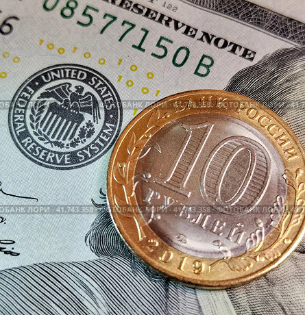Десятирублевая монета лежит на купюре 100 долларов, около эмблемы Федеральной Резервной Системы. Стоковое фото, фотограф Цибаев Алексей / Фотобанк Лори