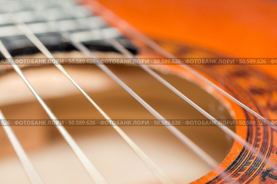 Detail of classic acoustic guitar with shallow depth of field.. Detail of classic acoustic guitar with shallow DOF and blur. Стоковое фото, агентство Ingram Publishing / Фотобанк Лори