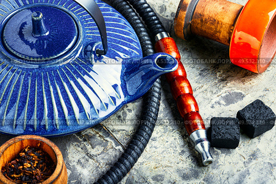 Details of tobacco hookah and teapot with tea.Egyptian smoking shisha and teakettle. Oriental hookah with kettle. Стоковое фото, агентство Ingram Publishing / Фотобанк Лори