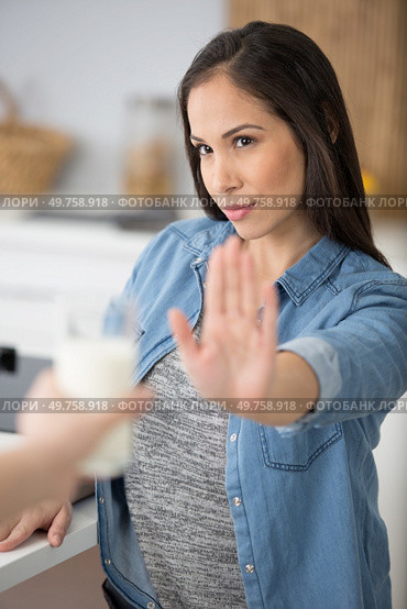 determined woman refusing a glass of cold milk. Стоковое фото, агентство Ingram Publishing / Фотобанк Лори