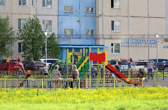 Дети и взрослые на детской площадке во дворе дома. Город Надым, Ямало-Ненецкий автономный округ (2023 год). Редакционное фото, фотограф Григорий Писоцкий / Фотобанк Лори