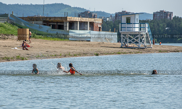 Дети весело проводят время, купаясь на пляже городского озера, город Железногорск, Красноярский край. Редакционное фото, фотограф Анатолий Володин / Фотобанк Лори