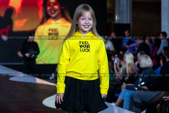 Девочка демонстрирует одежду из коллекции российского бренда Lucky child на подиуме фестиваля детской моды KIDS FASHION WEEK в "Центральном детском магазине на Лубянке" (ЦДМ) в Москве, Россия (2023 год). Редакционное фото, фотограф Николай Винокуров / Фотобанк Лори