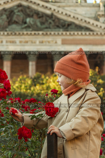 Девочка любуется красными розами. Стоковое фото, фотограф FOTOvZAPASE / Фотобанк Лори