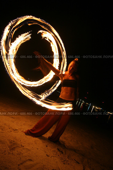 Девушка исполняет танец с огнём (fireshow) ночью на пляже. Стоковое фото, фотограф Алексей Корсаков / Фотобанк Лори
