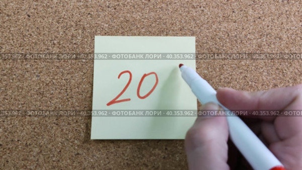 Девушка пишет надпись 20% красным маркером на желтом бумажном стикере, приклеенном к пробковой доске. Женская рука с цветным фломастером. Рукописный текст красивым почерком. Процент скидки, убытка или прибыли. Girl writes the inscription 20% with red marker on yellow paper sticker glued to cork board. Woman hand with colored felt-tip pen. Handwritten text in beautiful handwriting. Percentage of discount, loss or profit. Стоковое видео, видеограф Ирина / Фотобанк Лори