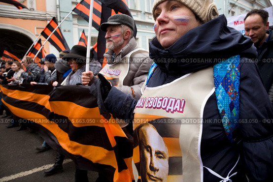Девушка с георгиевской лентой и портретом президента Владимира Путина на шествии в поддержку соотечественников на Украине, Москва (2014 год). Редакционное фото, фотограф Николай Винокуров / Фотобанк Лори