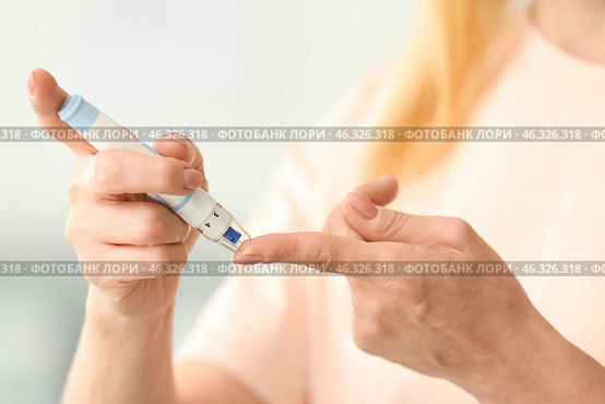 Diabetic woman taking blood sample with lancet pen at home, closeup. Стоковое фото, фотограф Pixel_shot / Фотобанк Лори