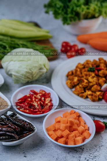 Diced carrots, dried chilies, roasted rice, chili, and cabbage are placed on a cement floor. Стоковое фото, агентство Ingram Publishing / Фотобанк Лори